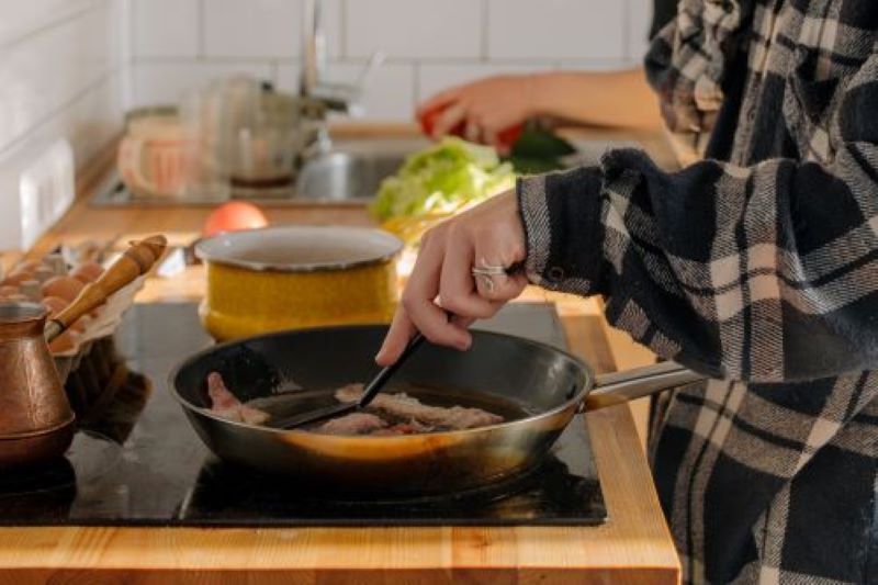 Frau kocht auf Kochfeld