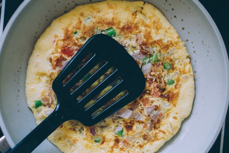 Mit dem Pfannenwender aus Kunststoff ein Omelett wenden