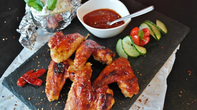 Chicken Wings und Salat auf einer Schiefertafel Weiteres Essen, das mit einem Dönergrill zubereitet werden kann.