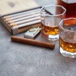 Zwei Gläser Whiskey, Zigarren und eine Karaffe