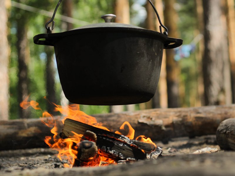 Feuertopf zum Aufhängen am Dreifuß Feuertopf ueber einem Lagerfeuer