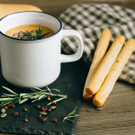 Suppentasse mit Kürbissuppe und Grissinis