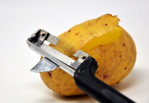 Pendelschäler schält eine Kartoffel